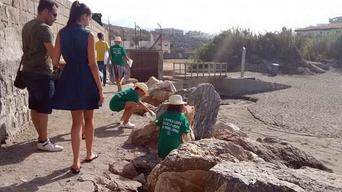 Niños llevando a cabo la limpieza de una de las playas de la Villa.