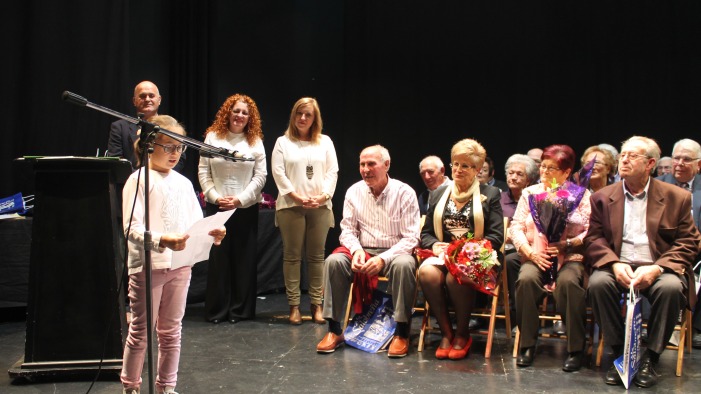 Una niña lee un mensaje a los homenajeados.
